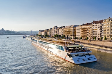 River cruise in Western Europe cruising close to the shoreline with tall condominiums
